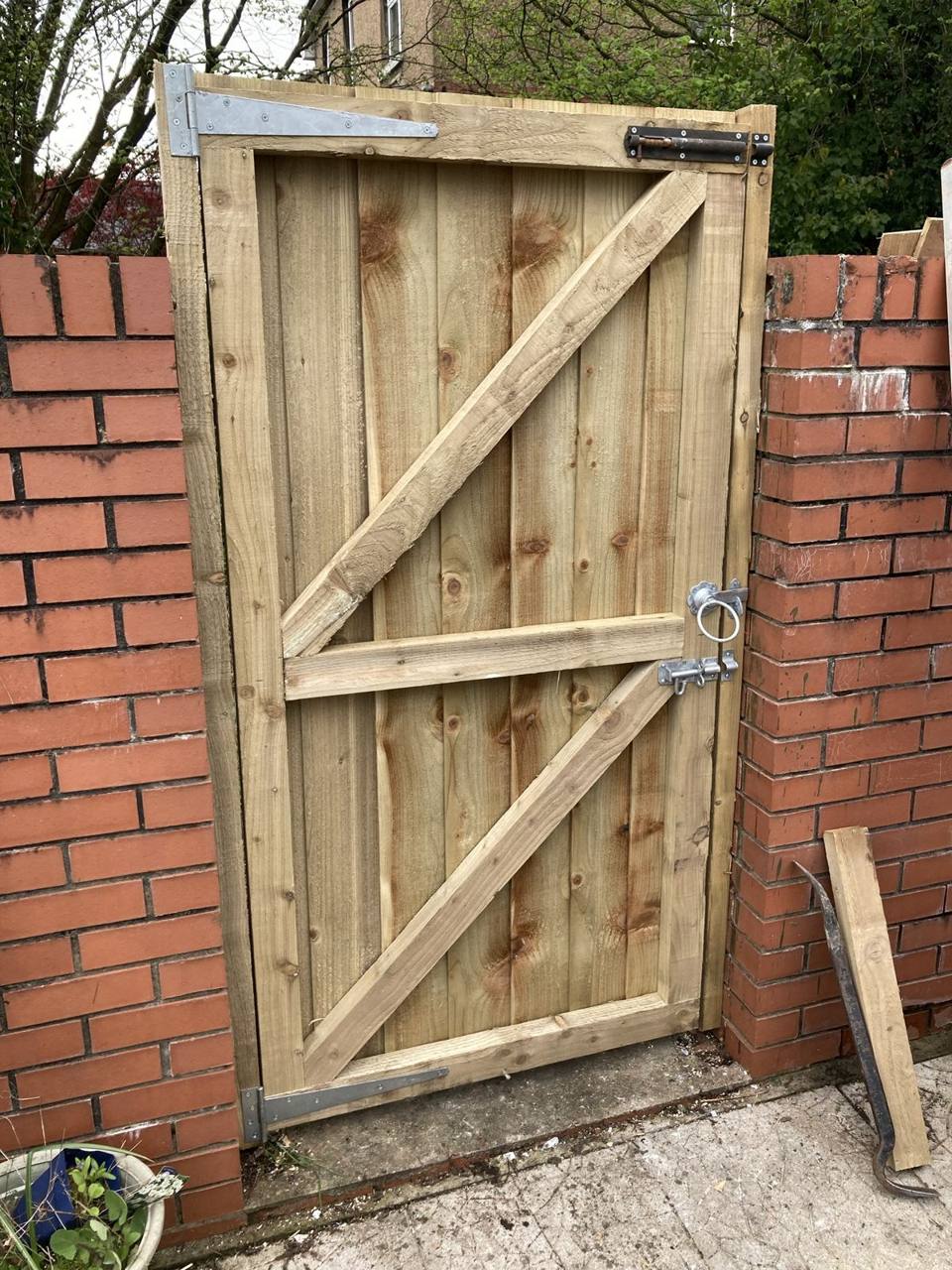 Back of the same gate showing the ledged and braced frame and heavy hinges